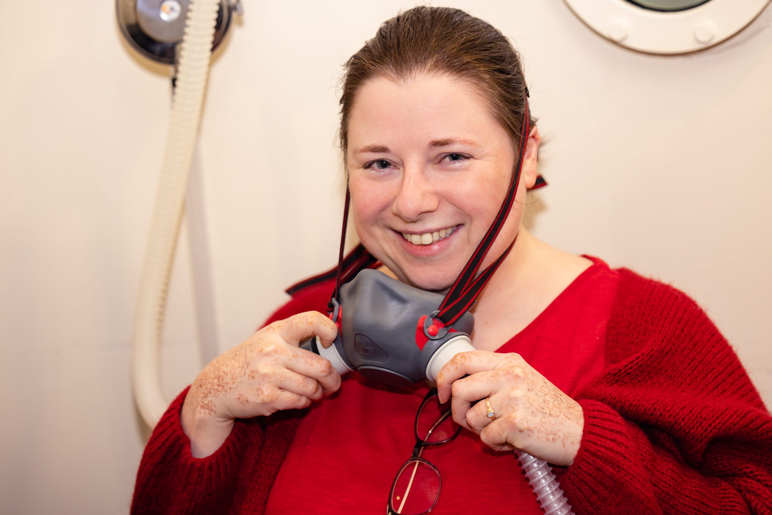 Smiling woman putting on oxygen mask